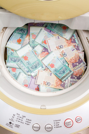 Money laundering concept with Ringgit Malaysia notes in washing machine.の写真素材