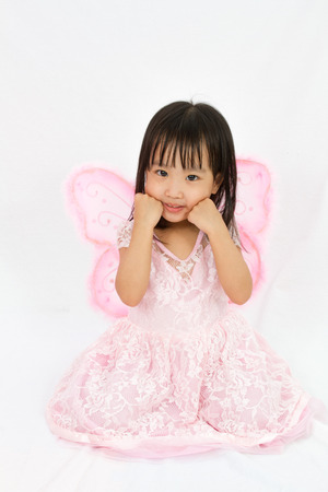Chinese little girl wearing butterfly custome in plain white backgroundの写真素材