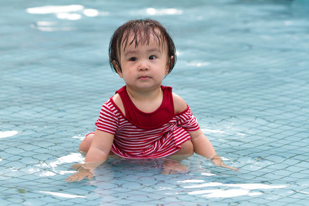 Chinese Little Girl Playing in Water in Swimming Poolの写真素材