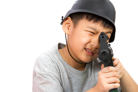Asian Little Boy Playing Plastic Toy AK47 with Police Helmet on White Backgroundの写真素材