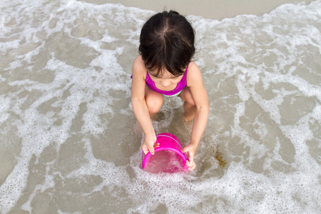 Asian Little Chinese Girl Playing with Beach Toys on Tropical Beachの写真素材
