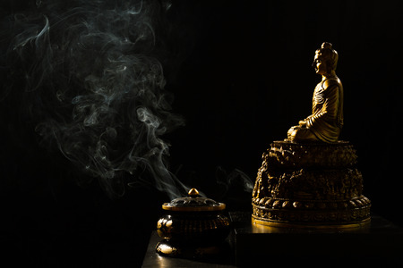 Sitting Bronze Budda with Incense Burner in isolated Black Backgroundの写真素材