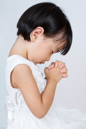 Asian Little Chinese Girl Praying in isolated White Backgroundの写真素材