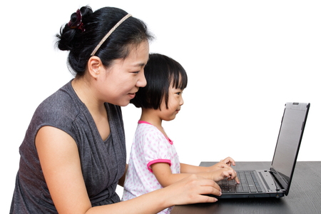 Asian Mother and Daughter Using Laptop Computer in Isolated White Backgroundの写真素材