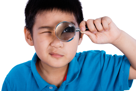 Asian Chinese Boy Holding Magnifying Glass isolated on White Backgroundの写真素材