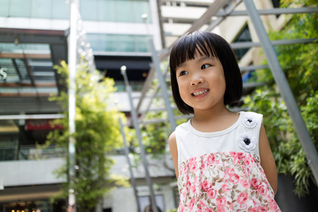 Asian Chinese little girl smiling with building background