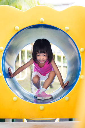 Asian Chinese little girl crawling at outdoor playgroundの写真素材