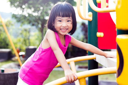 Asian Chinese little girl climbing at outdoor playground.の写真素材