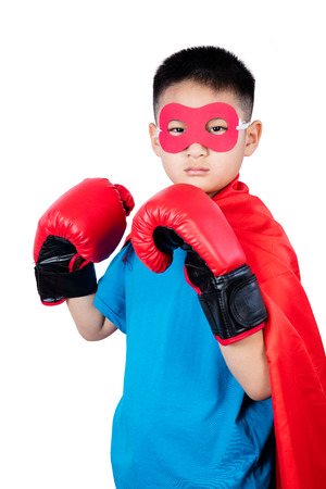 Asian Chinese boy wearing super hero costume with boxing gloves in isolated plain white background.の写真素材