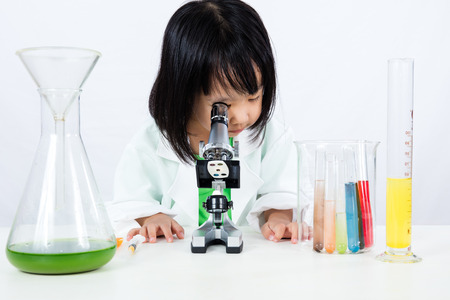 Asian Chinese Little Girl Working With Microscope in isolated white background.