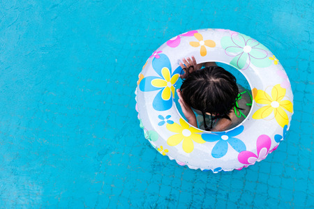 Asian Chinese Little Girls Swimming In The Outdoor Pool with inlfatable ring.の写真素材