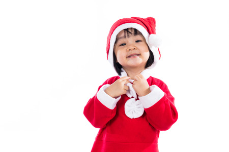 Happy Asian Chinese little girl wearing santa claus costume in isolated white background.の写真素材