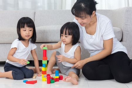 Asian Chinese mother and daughter playing blocks on the floor in the living room at home.の写真素材