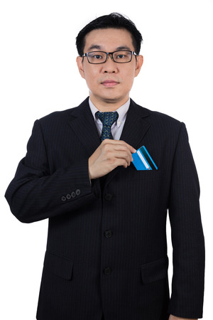 Smart Asian Chinese man wearing suit and holding credit card in isolated white background.の写真素材