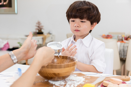Asian Chinese little boy prepare for baking cookies at homeの写真素材