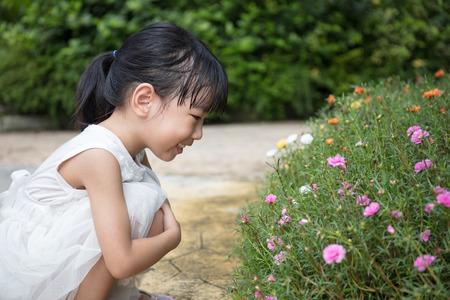 Asian Chinese little girl playing in outdoor garden on day timeの写真素材