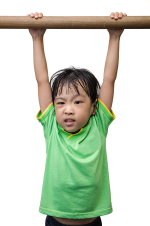 Asian Chinese little girl hanging on horizontal bar in isolated white background