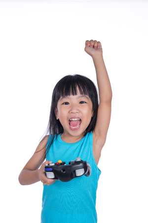Asian Chinese little girl playing game with controller in isolated white backgroundの写真素材