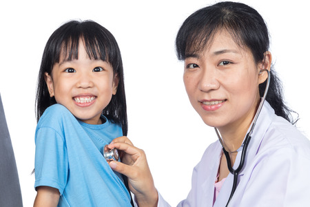 Asian female doctor examining a Chinese little girl by stethoscope in isolated White Backgroundの写真素材