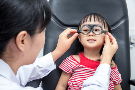Asian Little Chinese Girl Doing Eyes Examination by ophthalmologist at An Optical Shopの写真素材