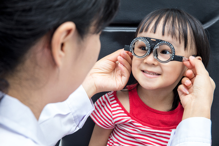 Asian Little Chinese Girl Doing Eyes Examination by ophthalmologist at An Optical Shopの写真素材