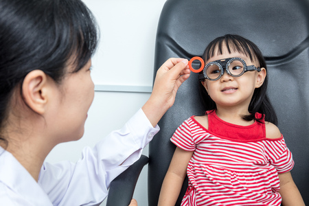 Asian Little Chinese Girl Doing Eyes Examination by ophthalmologist at An Optical Shopの写真素材