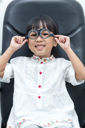 Asian Little Chinese Girl Doing Eyes Examination at An Optical Shopの写真素材