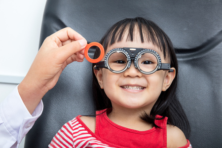 Asian Little Chinese Girl Doing Eyes Examination at An Optical Shopの写真素材
