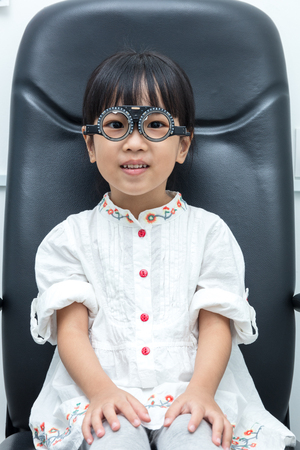 Asian Little Chinese Girl Doing Eyes Examination at An Optical Shopの写真素材