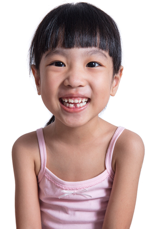 Happy Asian Chinese little girl with toothless smile in isolated white backgroundの写真素材