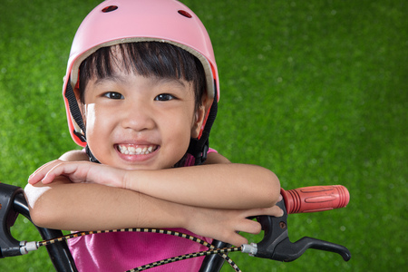 Asian Chinese little girl riding bicycle at outdoor parkの写真素材