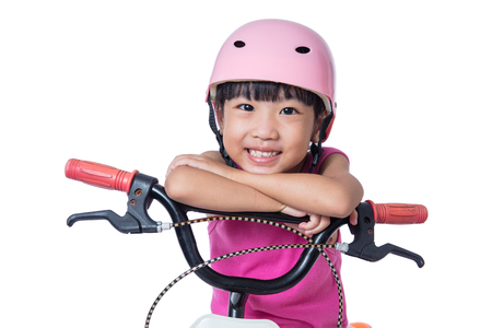 Asian Chinese little girl riding bicycle in isolated white backgroundの写真素材