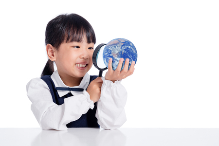 Asian Little Chinese Girl Looking At Globe Through Magnifying Glass in isolated White Backgroundの写真素材