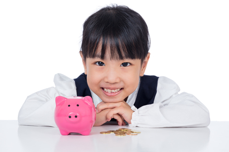 Asian Chinese little girl smiling with piggy bank in isolated white backgroundの写真素材
