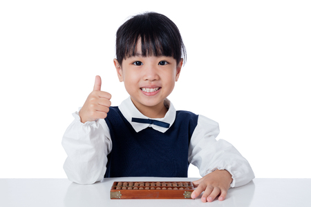 Asian Chinese little girl playing abacus in isolated white backgroundの写真素材