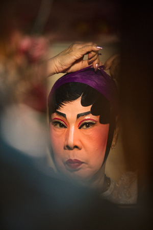 A member of a Chinese Opera group is reflected on a mirror as she prepares at backstage for a performance in Tanjung Sepat, Selangor, Malaysia on Wednesday, Jul. 19, 2017. 

The Opera Group is from Thailand Shengngoy Troupe, they perform the opera in Chinのeditorial素材