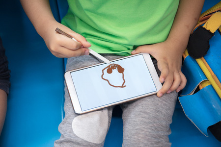 Asian Chinese little girl playing smart phone inside a MRT transitの写真素材