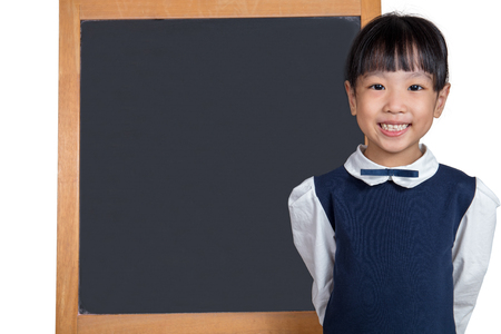 Asian Chinese little girl standing in front of blackboard in isolated white backgroundの写真素材