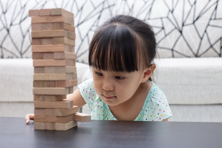 Asian Chinese little girl playing wooden stacks at homeの写真素材
