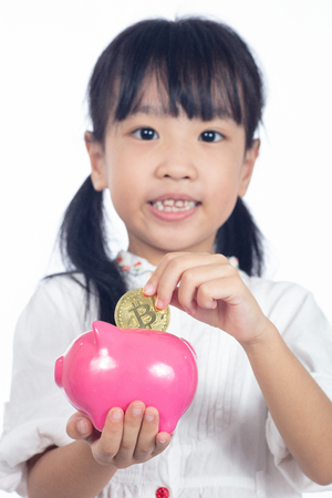 Asian Chinese little girl holding golden Bitcoin in isolated white backgroundの写真素材