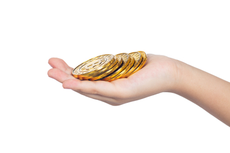Children's hand holding golden Bitcoin in isolated white backgroundの写真素材