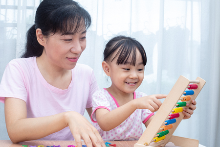 Happy Asian Chinese Family Playing Colorful Abacus Together at Homeの写真素材