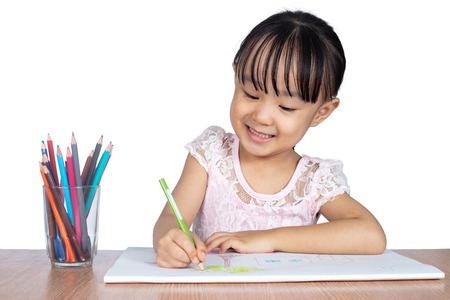 Asian Little Chinese girl painting on paper in isolated white backgroundの写真素材