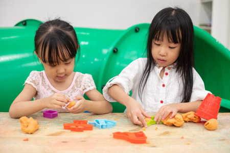 Asian Little Chinese Girls Playing Colorful Clay in Indoor Playgroundの写真素材