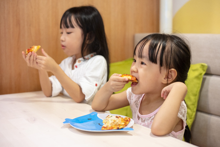 Asian Little Chinese sisters Eating sisters at restaurantの写真素材