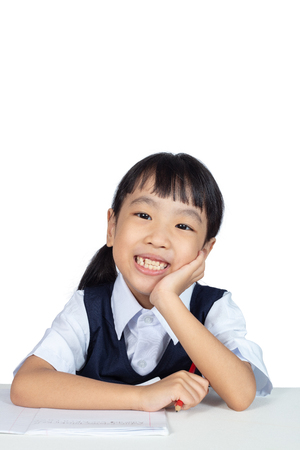 Asian Little Chinese Girl smiling with hand on chin in isolated white backgroundの写真素材
