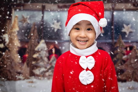 Asian Chinese little girl playing with snowflakes outdoor during christmas eveの写真素材