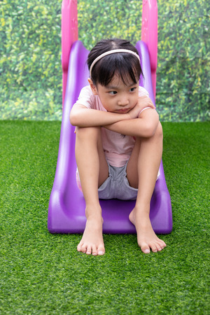 Asian Chinese Little Girl Playing on the slide at outdoor playgroundの写真素材