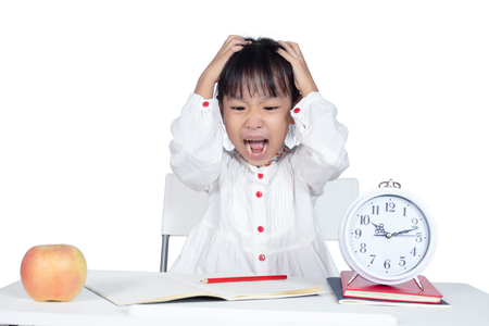 Asian Chinese Little Girl doing homework in isolated white backgroundの写真素材