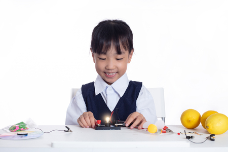 Asian chinese little girl doing experiments in isolated white backgroundの写真素材